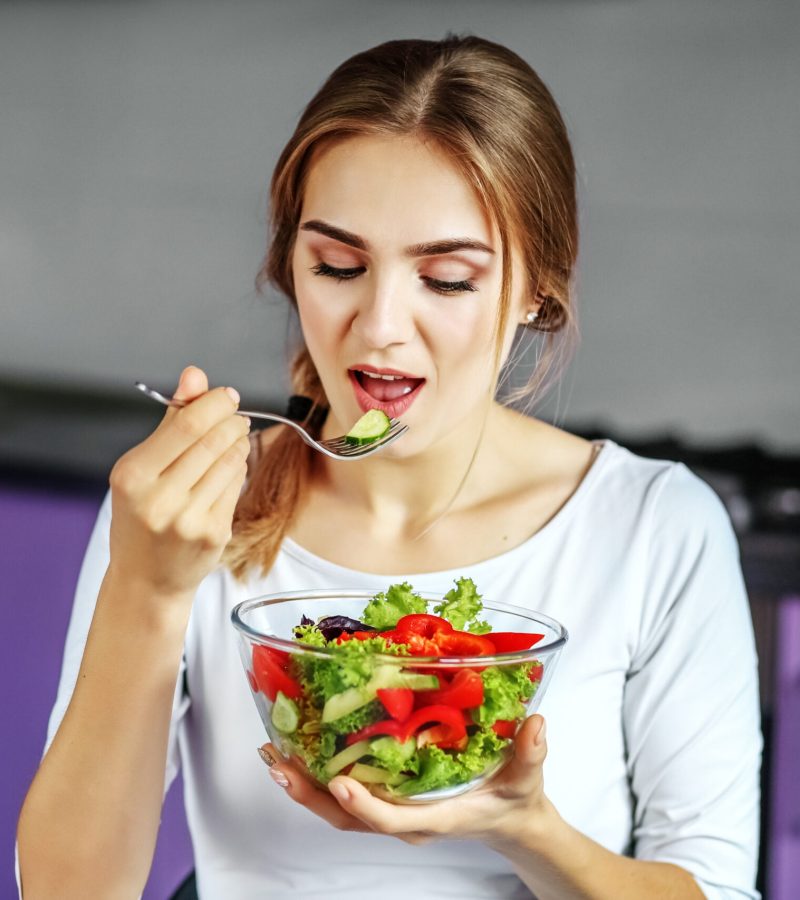 a-young-woman-eats-a-delicious-vegetable-salad-th-2022-02-08-02-45-26-utc-scaled.jpg
