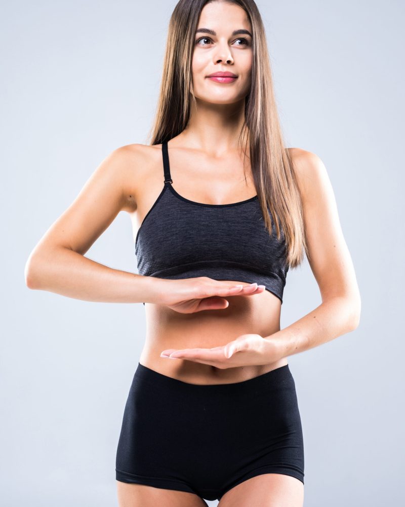 beautiful-portrait-woman-hand-gesture-heart-shape-belly-girl-wearing-sport-clothing-with-exercising-isolated-white-scaled.jpg