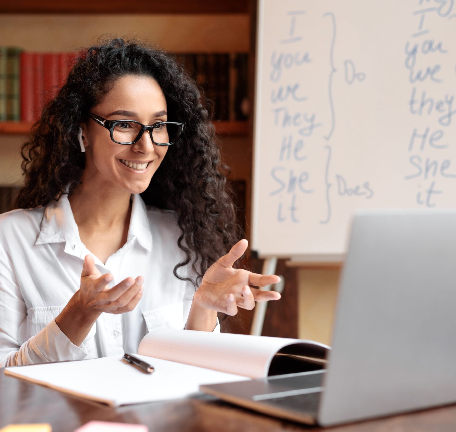 english-teacher-sitting-at-desk-explaining-lesson-8LYLCGK-scaled.jpg