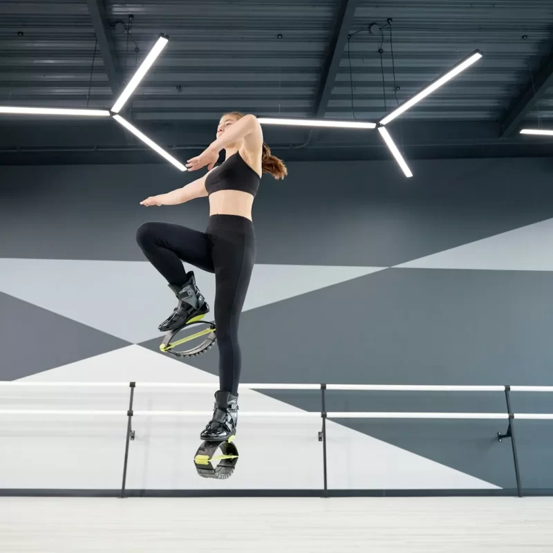 smiling-female-teen-practicing-kangoo-jumps-indoors.webp