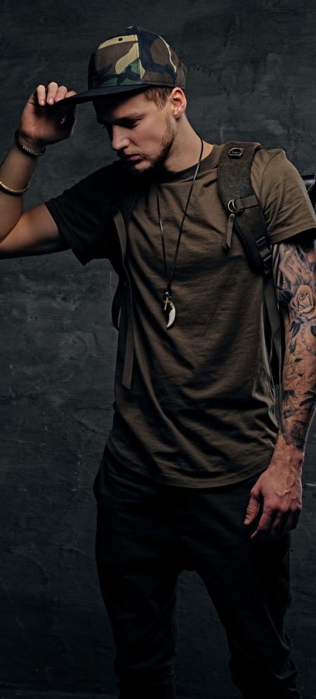 urban-style-backpacker-with-tattooed-arms-dressed-dark-green-t-shirt-camo-cap-scaled.jpg
